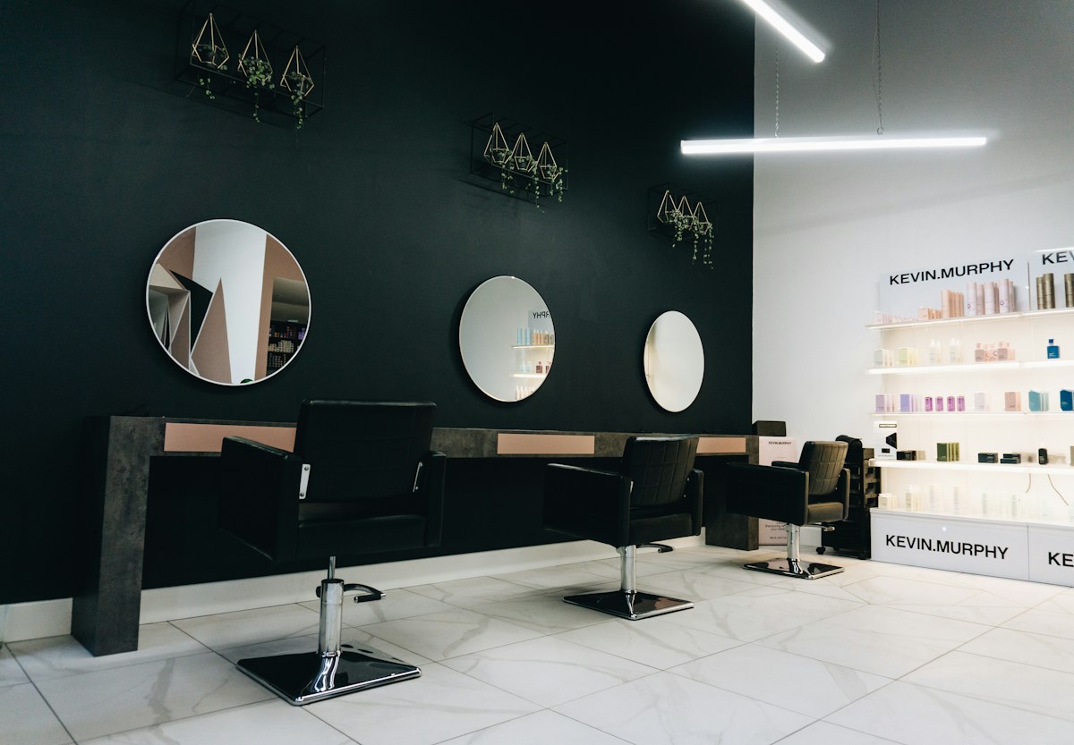 Voorbeeldinterieur met kappersstoelen en ronde spiegels
